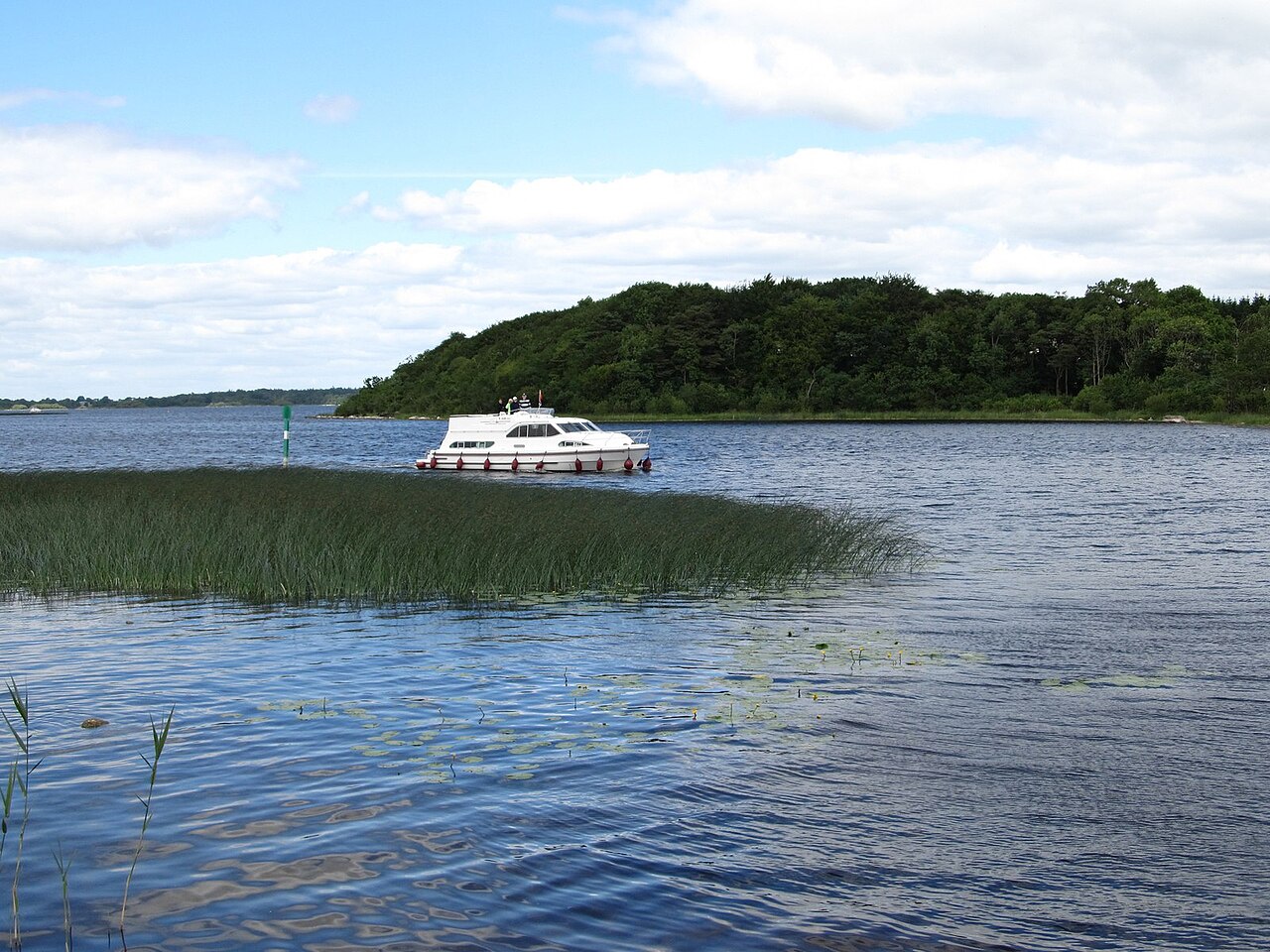 A motor cruiser on Lough Ree at Coosan Point near Athlone, with open water and blue sky.