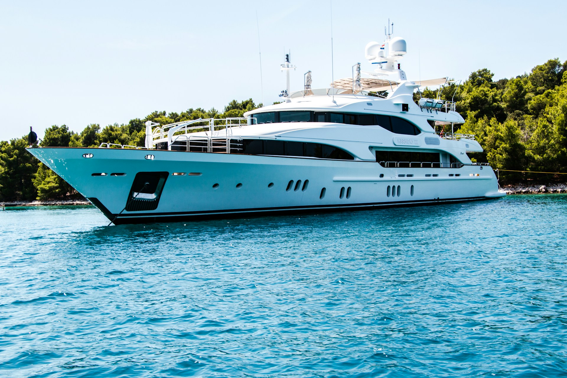 A white motor yacht at anchor on sheltered water